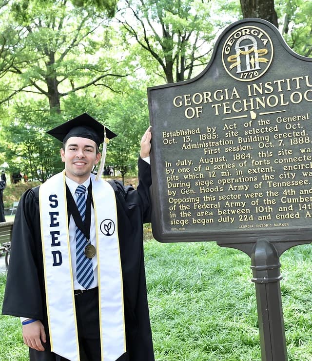 Chris Ozgo smiling in graduation regalia